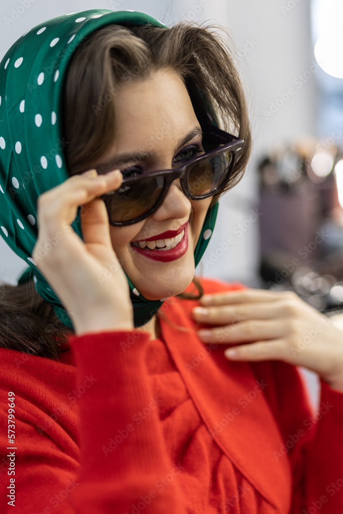 Portrait of attractive beautiful fashionable young woman dressed in the style of 1980s, with bright fancy make up, red sweater, glasses. Inspiration and vibes of 80s Portrait of attractive beautiful fashionable young woman dressed in the style of 1980s, with bright fancy make up, red sweater, glasses. Inspiration and vibes of 80s