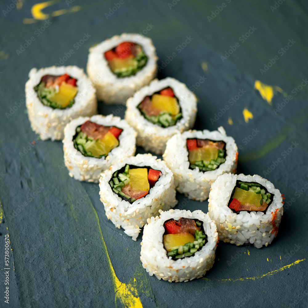 Sushi rolls with pepper, cucumber and tuna. Uramaki in sesame. Japanese food. Seafood dishes. Low calorie food. Fitness roll. Grey background. Top view. Copy space. Soft focus. Sushi rolls with pepper, cucumber and tuna. Uramaki in sesame. Japanese food. Seafood dishes. Low calorie food. Fitness roll. Grey background. Top view. Copy space. Soft focus.