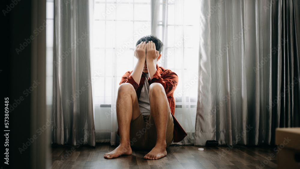 Fototapeta premium Asian Man sit Depression Dark haired pensive glance Standing by window and anxiety Copy space.