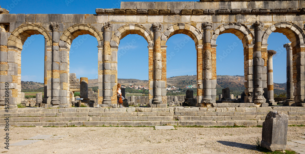 Fototapeta premium Woman tourist enjoying beautiful Volubilis site in Morocco, Meknes province