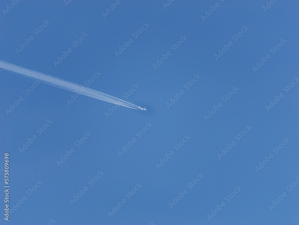 Photo of a plane leaving trails in the clear blue sky Photo of a plane leaving trails in the clear blue sky