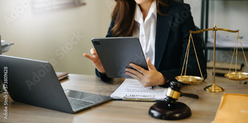 justice and law concept. asian woman lawyer working and judge in a courtroom the gavel, working with tablet and laptop and digital tablet computer