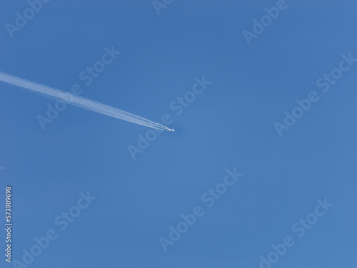 Photo of a plane leaving trails in the clear blue sky