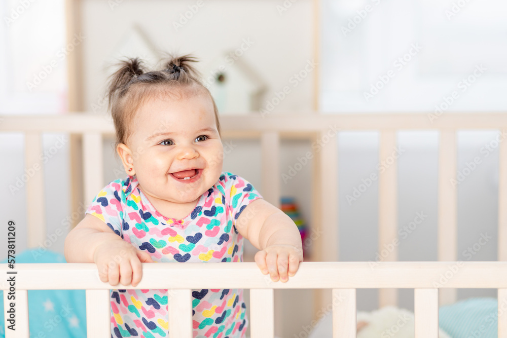 happy baby laughing at home in the nursery, portrait of baby in the crib happy baby laughing at home in the nursery, portrait of baby in the crib