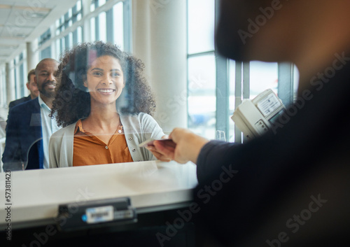 Black woman, ticket check and airport counter with a paper for travel or box office service. Happy customer person at consultant booth window for passport, work booking and buying pass at seller