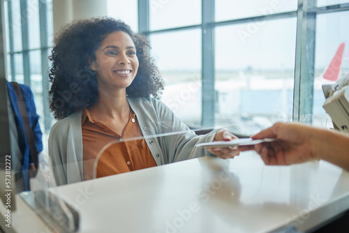 Foto Glass window, ticket check and black woman at airport counter with paper for travel or box office