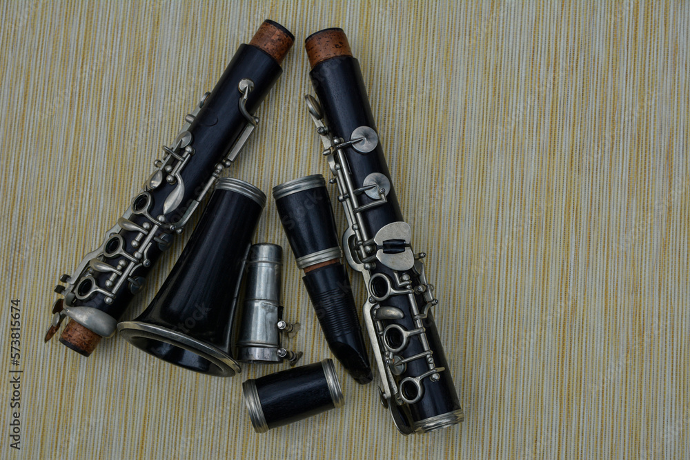 Naklejka premium The black clarinet was dismantled in parts against a yellow background.