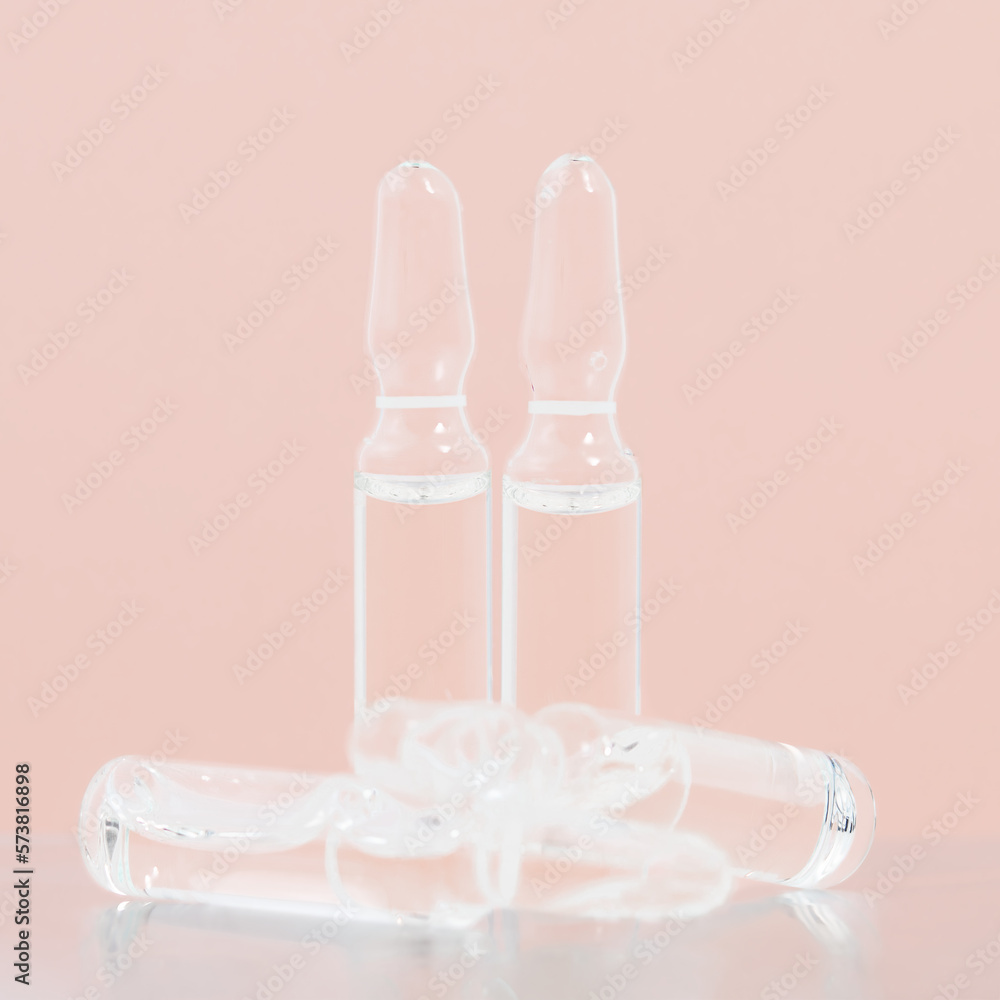 Ampoules with medicine on a pink background. Development and use of a cure for a new virus Ampoules with medicine on a pink background. Development and use of a cure for a new virus