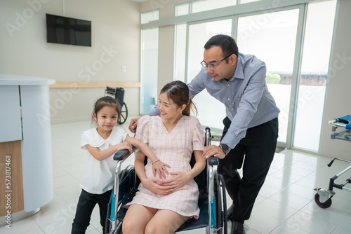 Portriat of happy family asian Pregnant middle aged mother, father and daughter at the hospital. Medical healthcare and healthy pregnancy concept.