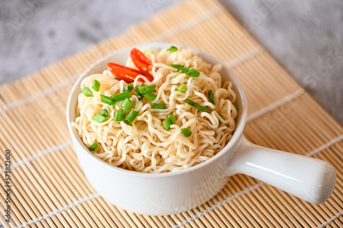 noodles bowl with vegetable spring onion and chili on wooden table food , instant noodles cooking tasty eating with bowl - noodle soup