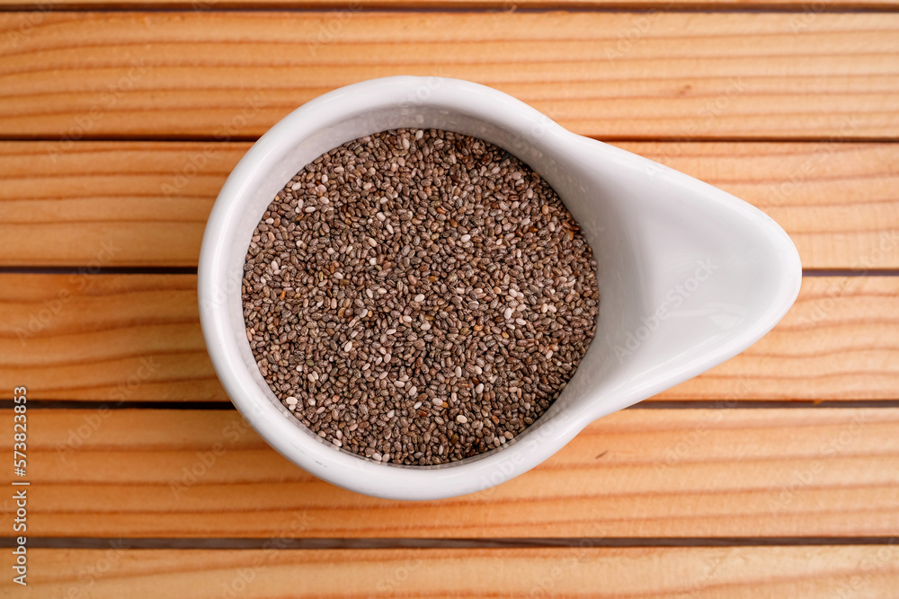 Chia seeds in a white bowl on a wooden table. Super food concept. top view Chia seeds in a white bowl on a wooden table. Super food concept. top view