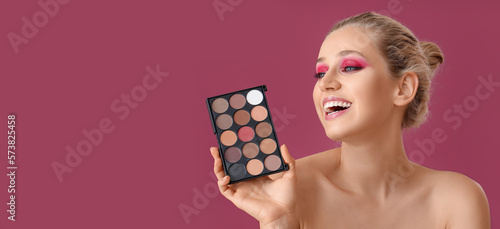 Photography Happy young woman with palette of beautiful eyeshadows on pink background with s