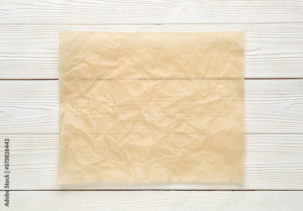 Sheet of baking paper on light wooden background