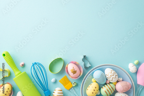Easter cooking concept. Top view photo of plates with easter eggs kitchen utensils and baking molds on isolated pastel blue background with blank space