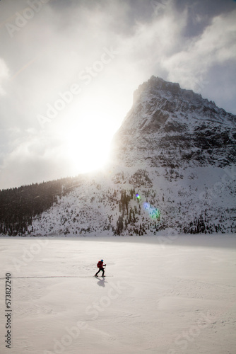 A woman skiing on Two Medicine Lake in front of Sinopah Mountain in Glacier National Park, Montana. photo