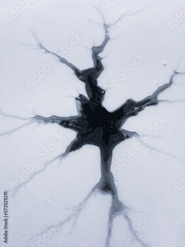 Cracked ice on frozen lake photo