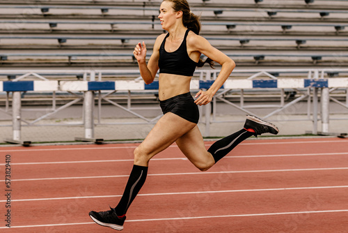 running training female athlete in compression socks on stadium