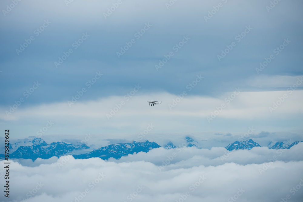 Plane flying over mountain peaks, Homer, Alaska, USA Plane flying over mountain peaks, Homer, Alaska, USA