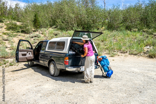 Woman loading luggage into truck at Piute Pass trailhead, Eastern Sierra, Bishop, California, USA photo
