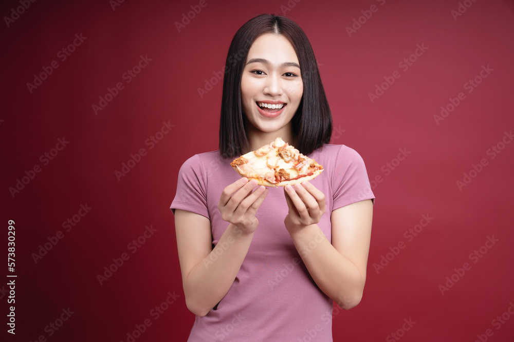 Young Asian woman eating pizza on background Young Asian woman eating pizza on background