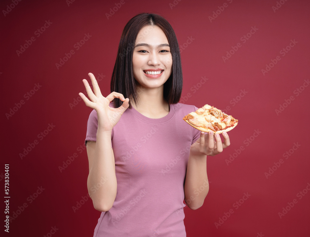 Young Asian woman eating pizza on background Young Asian woman eating pizza on background