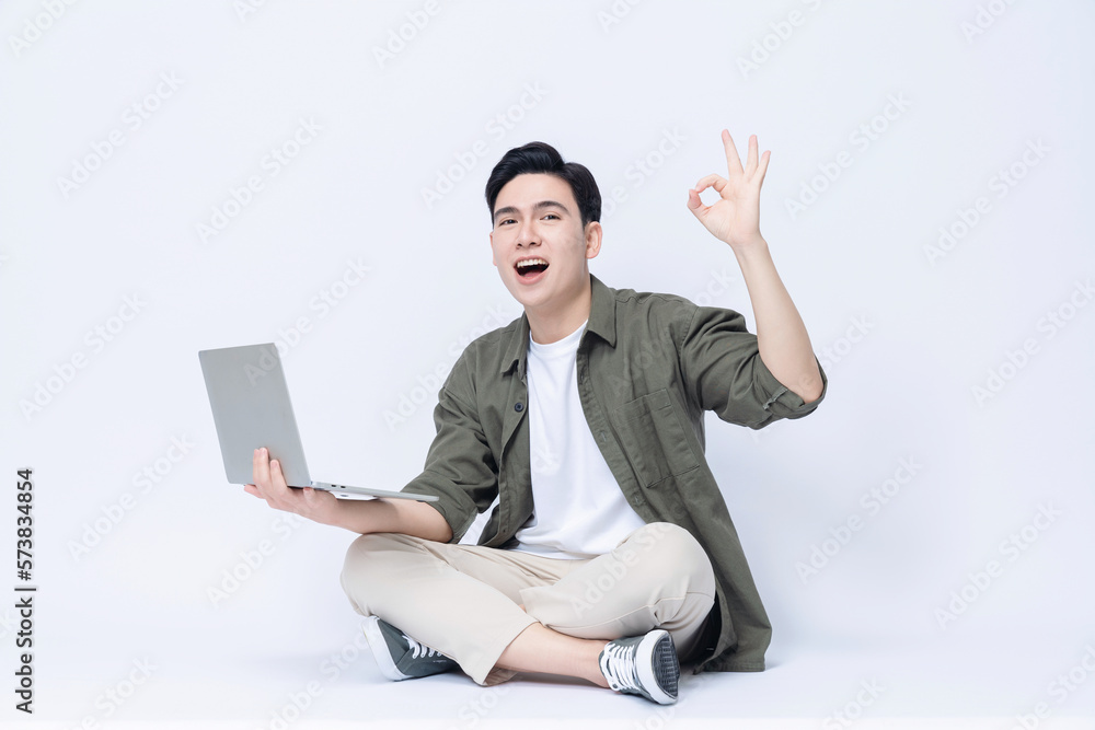 Young Asian business man sitting and using laptop on background Young Asian business man sitting and using laptop on background