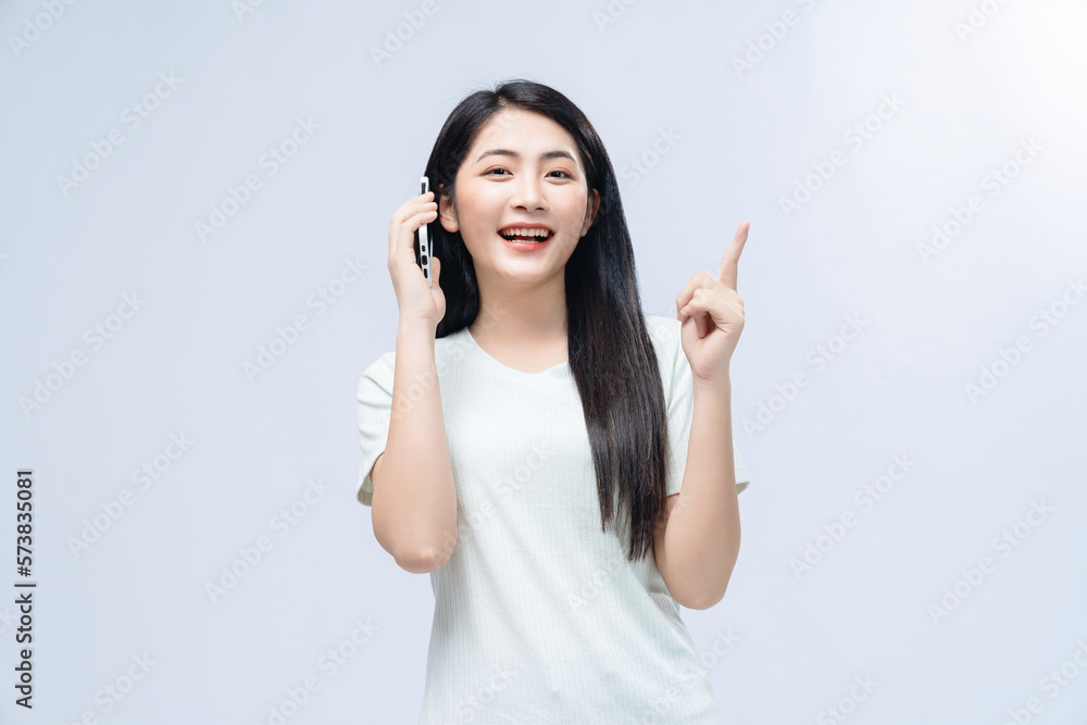 Young Asian girl using smartphone on background Young Asian girl using smartphone on background