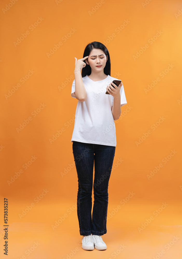 Young Asian girl using smartphone on background Young Asian girl using smartphone on background