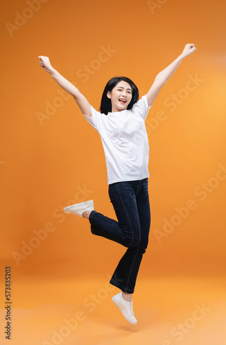 Full length image of young Asian girl on background