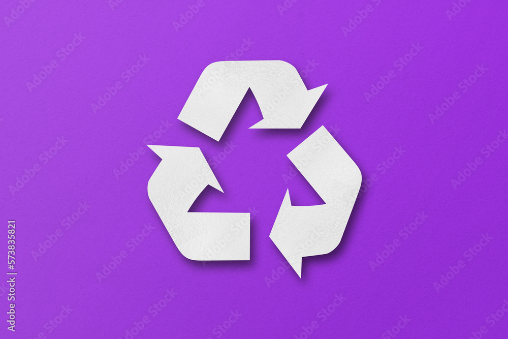 White paper cut into recycled shapes isolated on purple paper background. White paper cut into recycled shapes isolated on purple paper background.