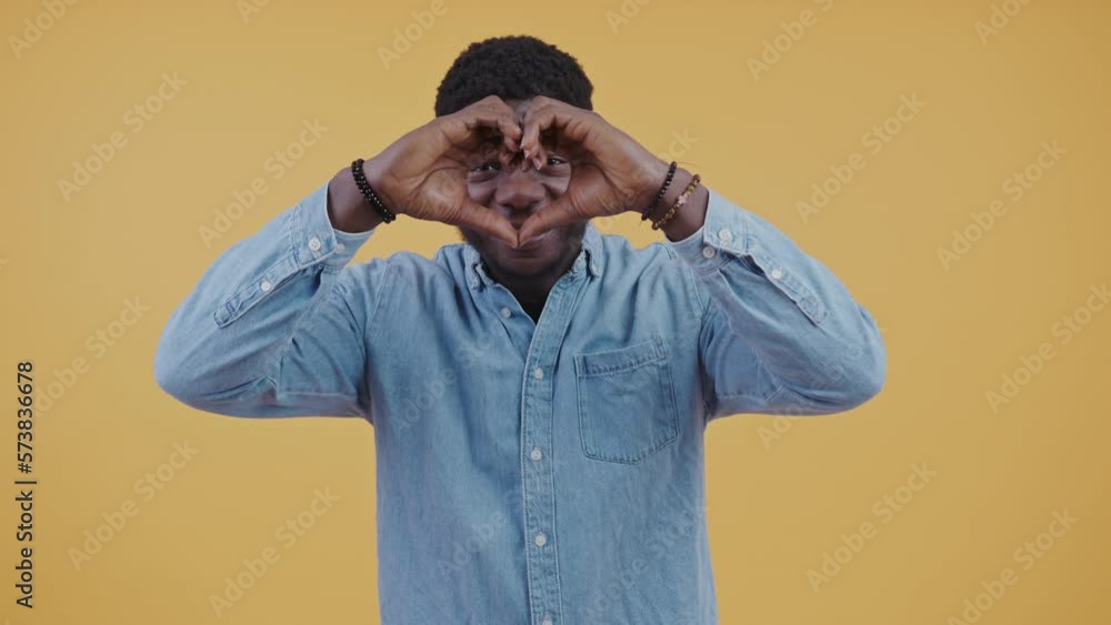 Cheerful black man making a heart with his fingers romantic being in love concept. High-quality 4k footage Cheerful black man making a heart with his fingers romantic being in love concept. High-quality 4k footage