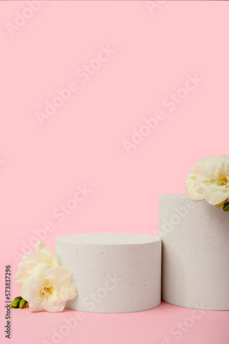 Podiums with beautiful flowers on pink background. Hello spring