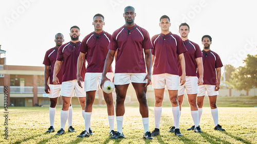Rugby, black man and strong team portrait on field, solidarity and confidence for winning game. Diversity, leadership and teamwork, group of strong sports people standing together in power on grass.