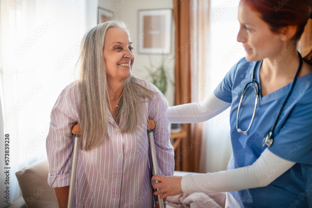Obraz premium Nurse helping senior woman with walking after leg injury.
