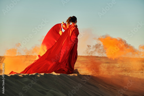 Woman in red dress dancing in the desert