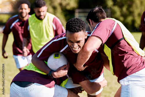 Team, tackle or rugby men in training, exercise or workout match on sports field running with a ball. Challenge, strong man or powerful group in tough competitive game with physical fitness or effort