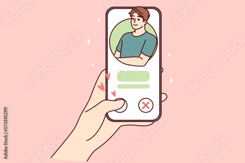 Woman hand with phone while using dating app or looking for couple for serious romantic relationship. Girl puts like man in mobile application of social network I wish to meet and go on date 