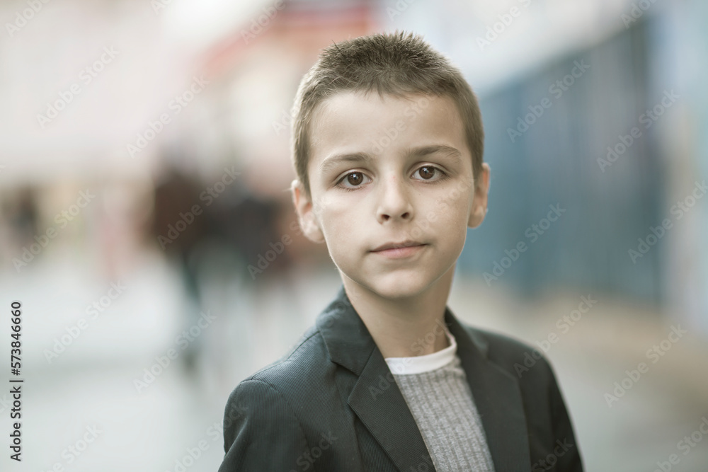 Fototapeta premium elegantly dressed handsome boy standing and walking the streets of the city