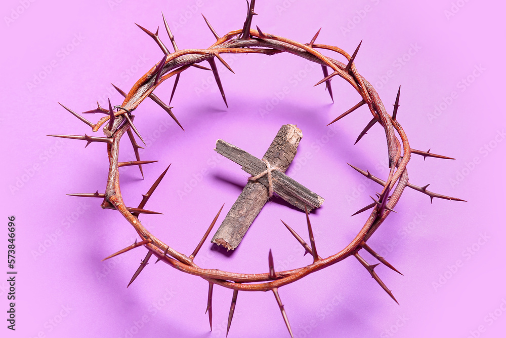 Crown of thorns with wooden cross on lilac background. Good Friday concept Crown of thorns with wooden cross on lilac background. Good Friday concept