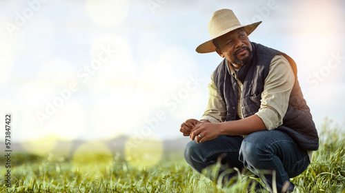 Farmer, black man and mockup for agriculture and sustainability outdoor on an agro farm with bokeh. Person on grass field thinking about farming innovation, growth and ecology in the countryside photo