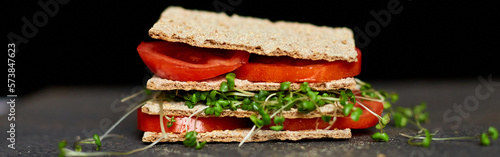 Foto Banner Healthy vegan sandwich with crisp rye bread tomatoe and microgreens on dark background, Diet nutritional food