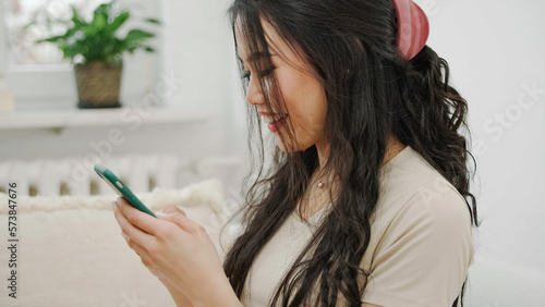 Young woman using smartphone at home.