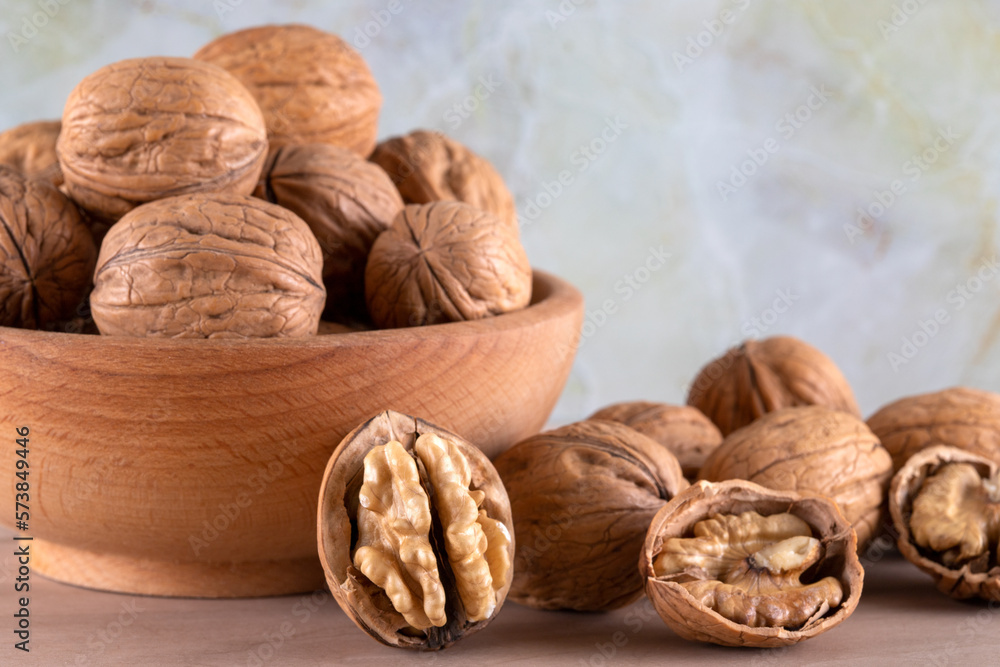 Walnut kernels and cracked walnuts on wooden background, front view Walnut kernels and cracked walnuts on wooden background, front view