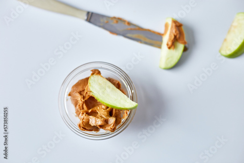 Green slices apples with peanut butter on white background, healthy snack, nutrition food, diet