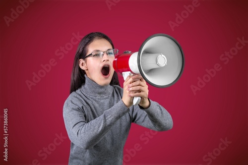 Young woman shouting in megaphone, activist concept.