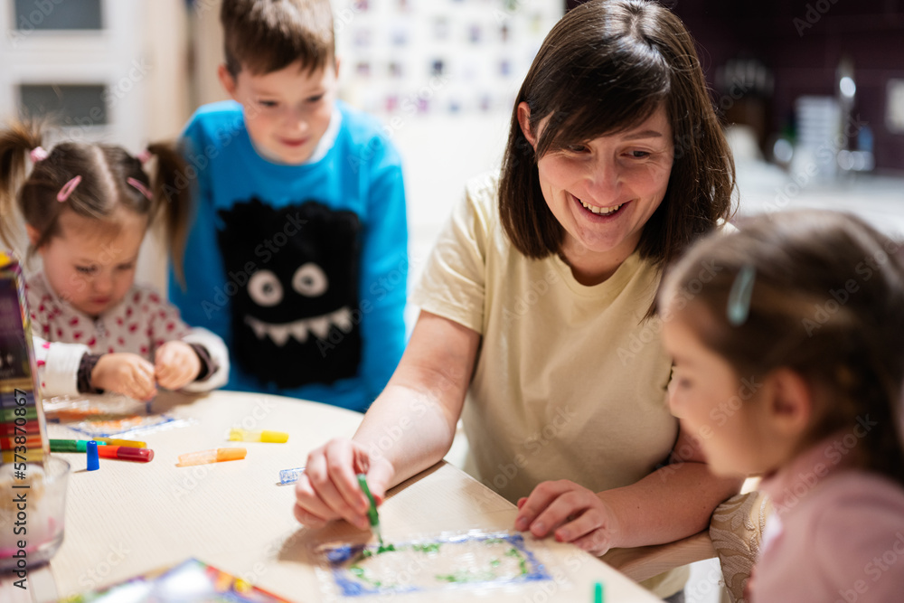 Mother and children decorating art with glitter decor. Mother and children decorating art with glitter decor.