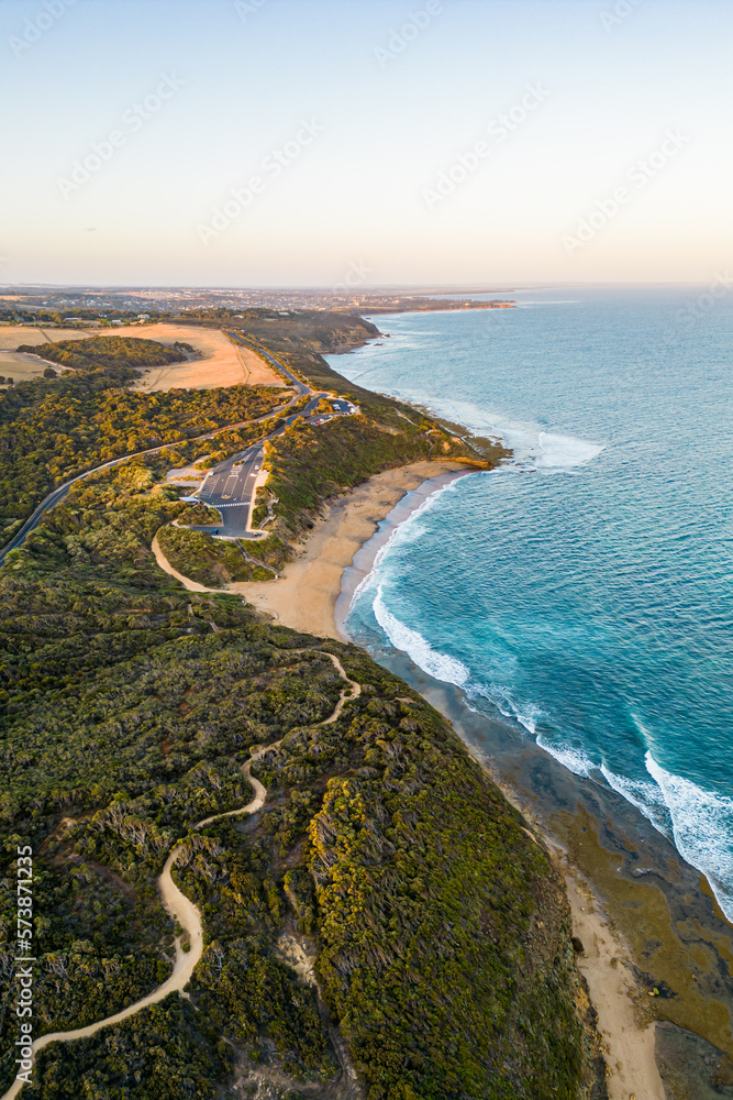 An aerial view of waves hitting Bells Beach at sunset in Torquay, Victoria, Australia. 