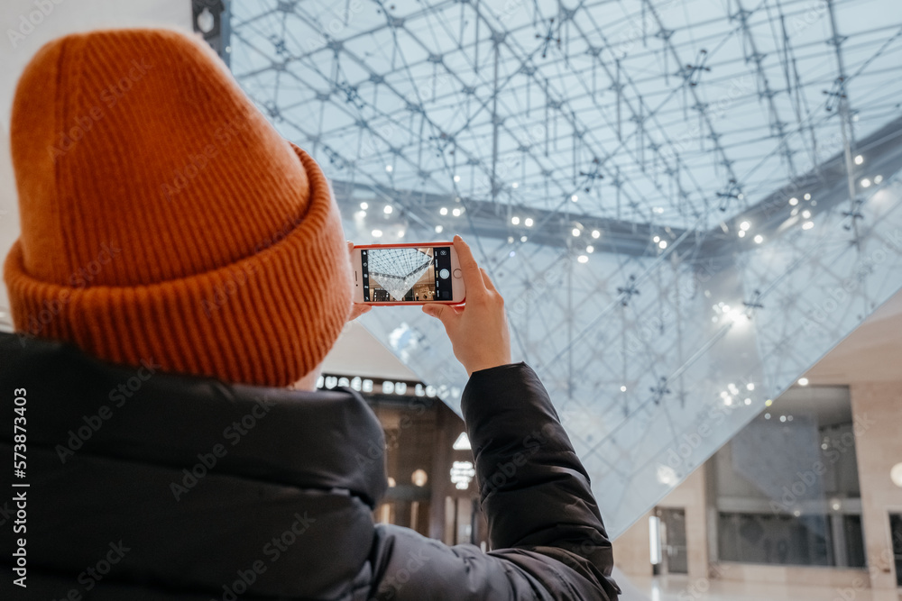 Foto de Young woman taking a photo. Inverted pyramid in the shopping