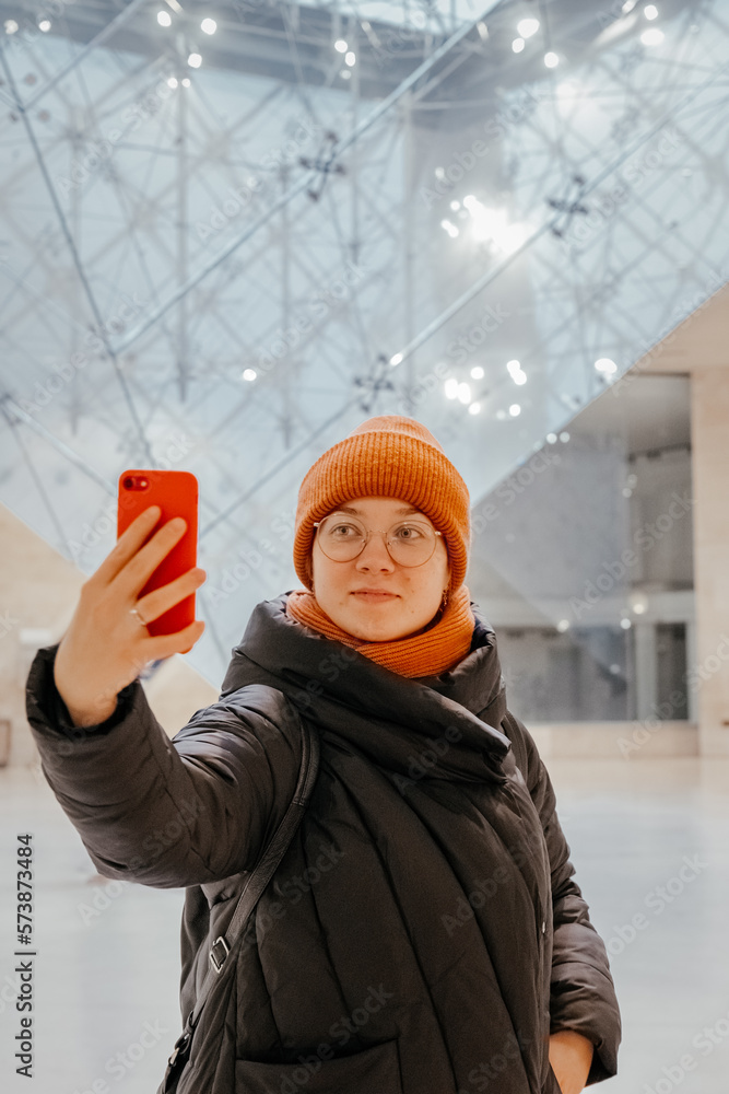 Young woman taking a selfie. Inverted pyramid in the shopping mall