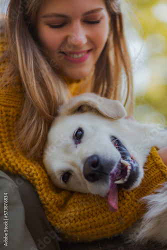 Belgrade, Serbia. November 10th, 2022. Beautiful young woman hugging her cute golden retriever outdoors on a sunny day.